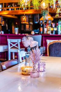 a table with a vase with pink flowers on it at Cosy Petten, Family only in Petten