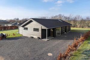 a house with a black roof on a driveway at SB128-Krusa-Hyldemose-23 in Skovbyballe
