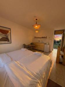 a bedroom with a large white bed and a table at Desert HoM by GLOW in Naẖal Shittim +31 photos