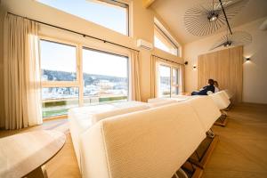 a row of white chairs in a room with large windows at Hotel Pehab - Rooftop-Spa in Ramsau am Dachstein +93 photos
