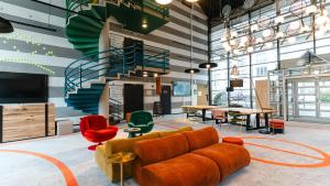a lobby with a couch and a table and chairs at Cowool Compiègne in Compiègne