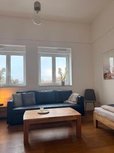 a living room with a blue couch and a coffee table at Westwind 2 in Steinfeld