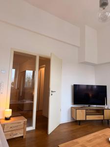 a living room with a flat screen tv on a white wall at Westwind 2 in Steinfeld