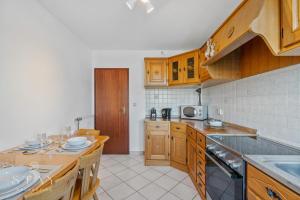 a kitchen with wooden cabinets and a counter top at Appartement à Schifflange in Schifflange +8 photos