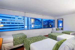 a hotel room with two beds and a view of the city at Hotel Oceanía Bogotá in Bogotá