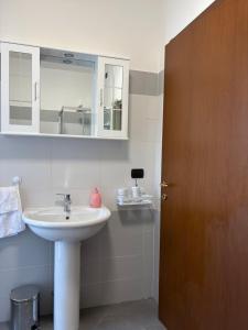 a bathroom with a sink and a wooden door at Casa Menotti in Carate Brianza