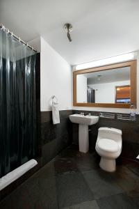 a bathroom with a toilet and a sink and a mirror at Hotel Oceanía Bogotá in Bogotá