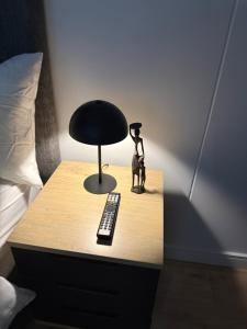 a table with a black lamp and a remote control at Elegant AirConditioned Neria at Ellipse Waterfall in Midrand