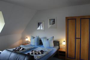 a bedroom with a bed with blue pillows at Landhaus Behrenwalde in Weitenhagen