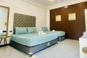 a bedroom with a large bed with a large headboard at Amaya View in Balulang