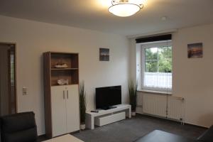 a living room with a tv and a window at Landhaus Behrenwalde in Weitenhagen