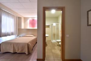 una camera d'albergo con un letto e un bagno di Tatì Hotel a Lugo
