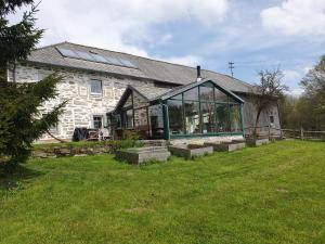 a stone house with a large glass window at Bio-Bauernhof, Pferdehof Gräser in Viehberg
