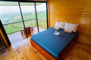 a bedroom with a blue bed with a large window at Amaya View in Balulang