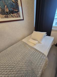 a bed with a pillow and a picture on the wall at Apartments at Koulukatu in Savonlinna