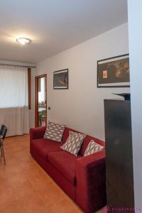 a living room with a red couch with two pillows at Casa da Luna in Parma