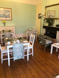 a living room with a table and chairs and a fireplace at Torwood House in Penzance