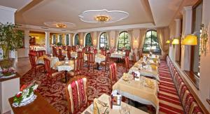 a restaurant with tables and chairs in a room at Hotel Berner in Zell am See