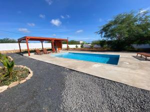a swimming pool with a gazebo next to at Magnifique villa avec piscine privée à 300m de la plage in Vila do Porto
