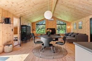 a kitchen and living room with a table and chairs at LK2209-Lokken-Soltoften-50 in Nørre Lyngby