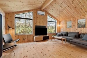 a living room with a couch and a flat screen tv at LK2209-Lokken-Soltoften-50 in Nørre Lyngby