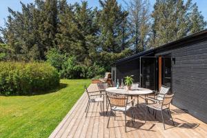 a patio with a table and chairs on a deck at LK2209-Lokken-Soltoften-50 in Nørre Lyngby