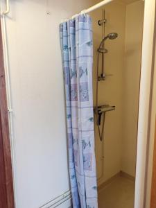 a shower curtain in a bathroom next to a showeroser at Vindslägenhet på Bjäre in Båstad