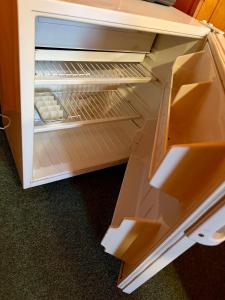 an empty refrigerator with its door open in a kitchen at Penzion Pstruh Stožec in Stožec