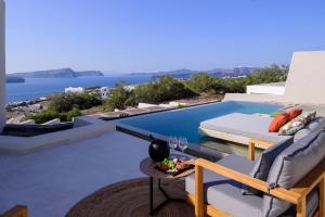 a villa with a view of the ocean and a pool at Potnia Theron Suites in Akrotiri