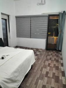 a bedroom with a bed and a large window at Funky Art Beach House in Alleppey