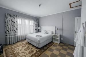a bedroom with a white bed and a window at Dreamers B&B in Maseru