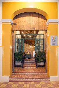 an entrance to a building with a yellow wall at Hotel La Posada del Doctor in León