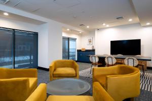 a room with chairs and a table and a tv at Kasa Sunset Los Angeles in Los Angeles