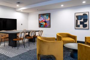 a room with a table and chairs and a tv at Kasa Sunset Los Angeles in Los Angeles