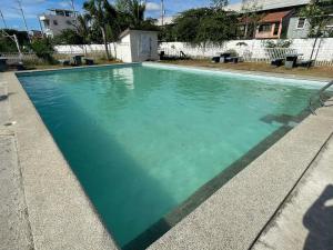 ein Schwimmbecken mit türkisfarbenem Wasser in der Unterkunft Chyns Suite in Marilao