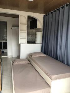 a small bedroom with two beds in it at Container Black in Pedra de Guaratiba