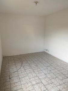 an empty room with a white wall and a tiled floor at Container Black in Pedra de Guaratiba