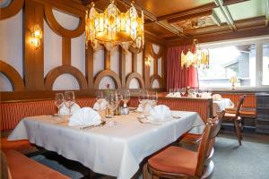 a dining room with a white table and a chandelier at Hotel Sonnhof in Innsbruck
