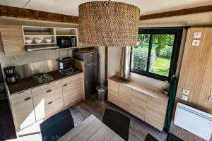 a kitchen in an rv with a table and a window at Camping Onlycamp Au Cœur du Lac - Lac d'Annecy in Sévrier