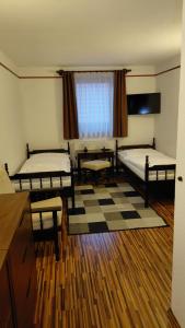 a room with two beds and a table and a window at Motel M in Malacky