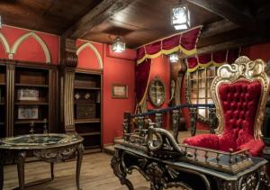 a room with red walls and a red chair and a table at Camping Les Sables d'Or Pirates World - Aquatique Vacances in Le Grau-dʼAgde