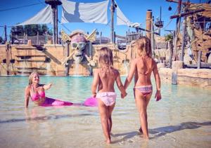 three girls in the water at a water park at Camping Les Sables d'Or Pirates World - Aquatique Vacances in Le Grau-dʼAgde