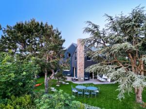 a house with a yard with tables and chairs at La villa M Vannes, villa les pieds dans l'eau sur le port, avec grand jacuzzi in Vannes