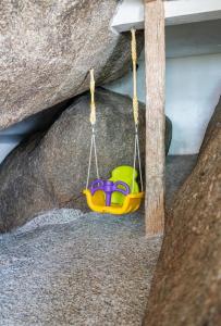 a toy swing hanging from a rock at The Rock Samui Beach Resort in Lamai