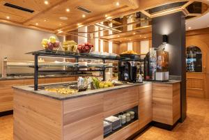 a kitchen with a counter with food on it at Hotel Isolabella Wellness in Fiera di Primiero