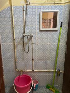 a shower with a pink bucket in a bathroom at GUESTS Of TATA in Tatta