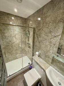 a bathroom with a shower and a toilet and a sink at King Alfred Hotel in Barrow in Furness +58 photos