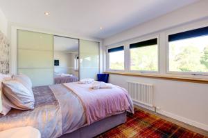 a bedroom with two beds and two windows at Loch Earn in Inverness +48 photos