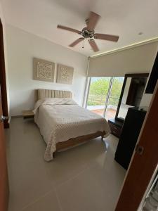 ein Schlafzimmer mit Bett und Deckenventilator in der Unterkunft CONDOMINIO LAGUNA CLUB "Amalfi" in Cartagena de Indias + 9 Fotos