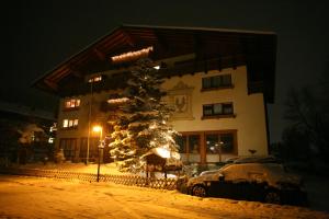 um edifício com uma árvore de Natal e um carro na neve em Altenmarkter Hof em Altenmarkt im Pongau